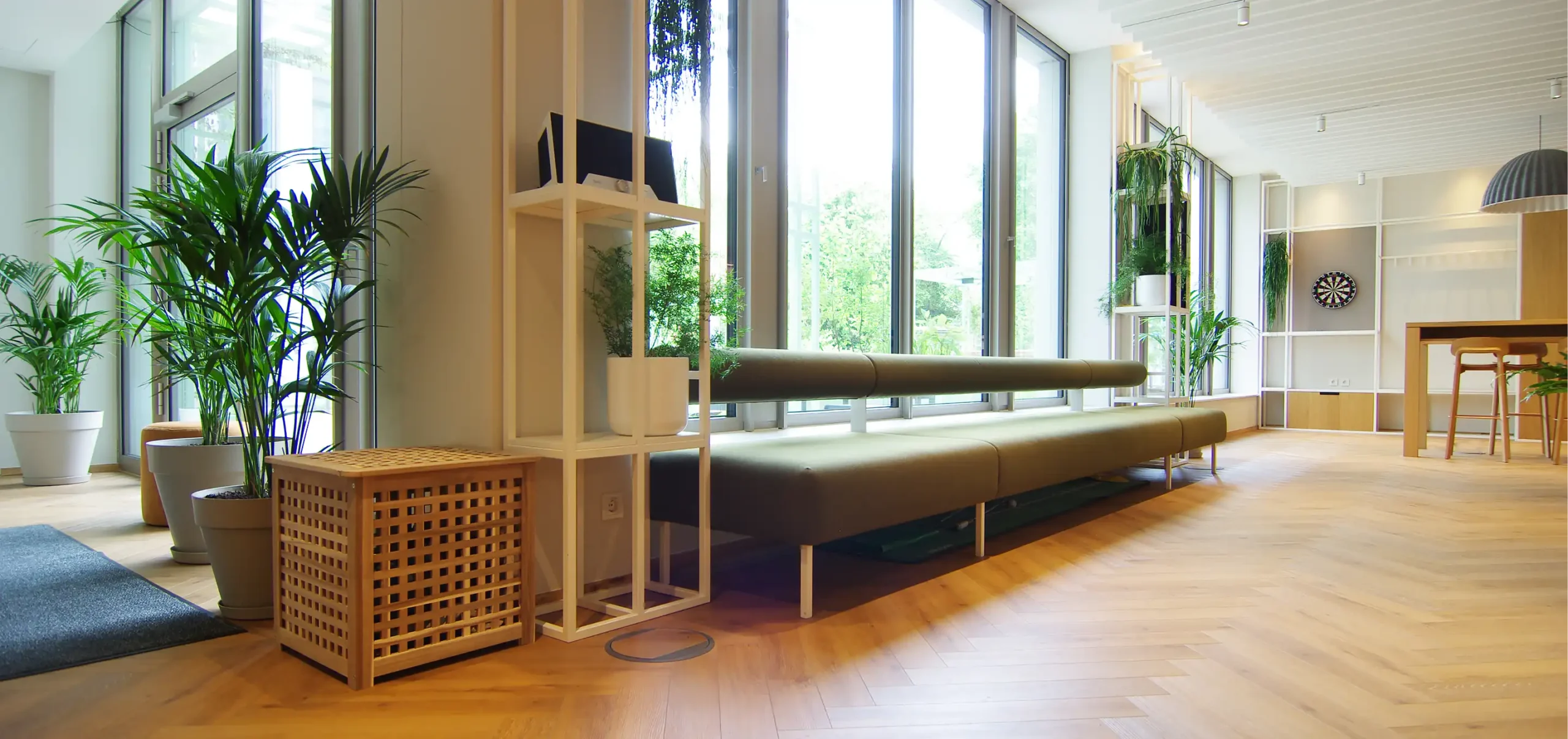 Büroräume von Bloom Offices, Fenster, grünes Polstermöbelstück, weiße Stahlregale und frische Grüntöne, Pflanzen