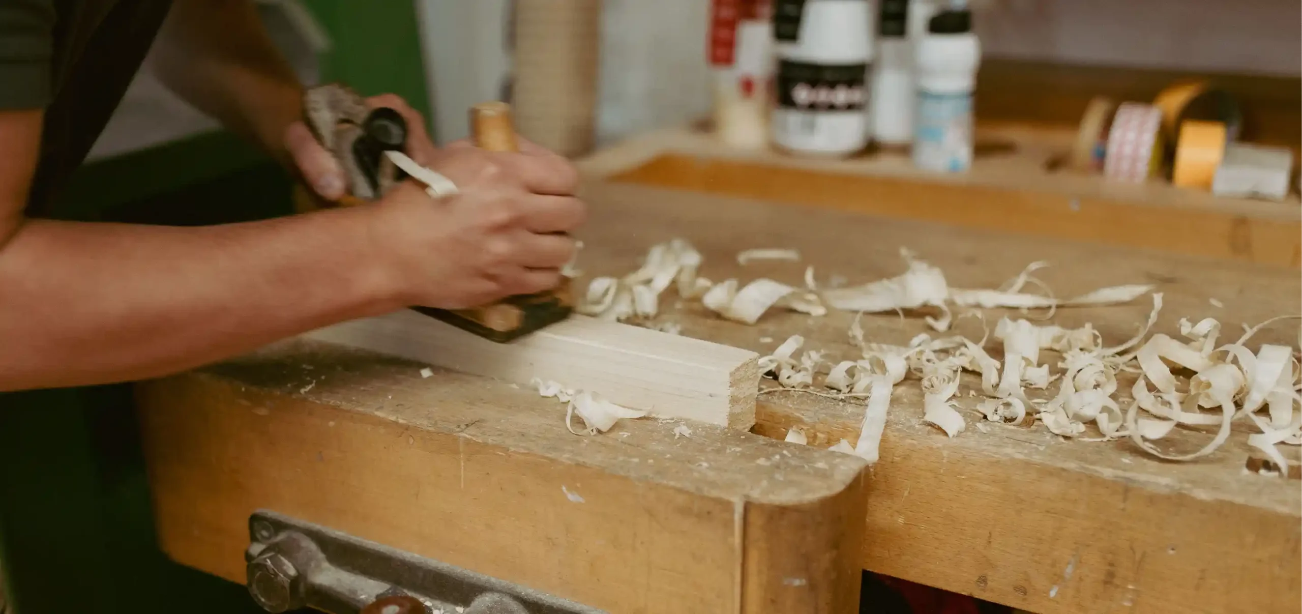 Holzwerkbank, Holzhobel, Sägespäne, Hände, Arbeiten mit dem Hobel