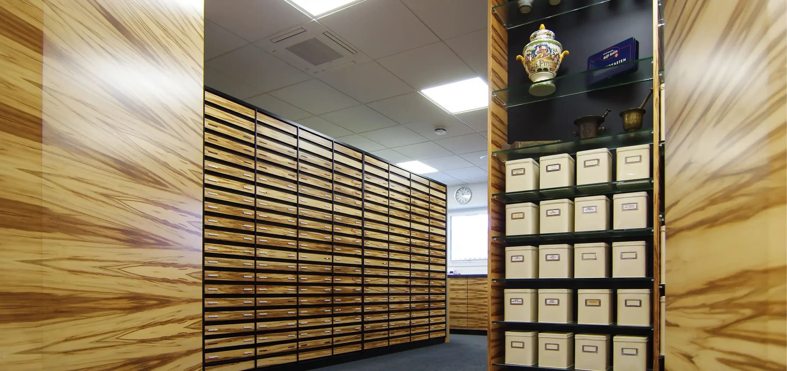Verkaufsraum Tal Apotheke, Wandschränke und Schränke mit Schubladen aus Holz, Regal mit Vase und Behältern