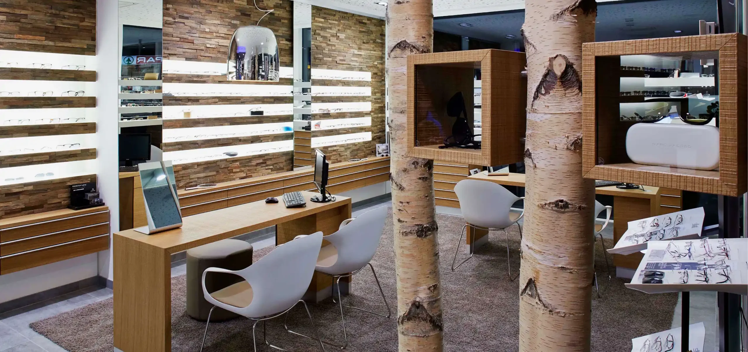 Optikergeschäft, Verkaufsraum, Regale in Birkenstämme gefasst, Optik Gundlof, Stadt: Reute, Land: Österreich