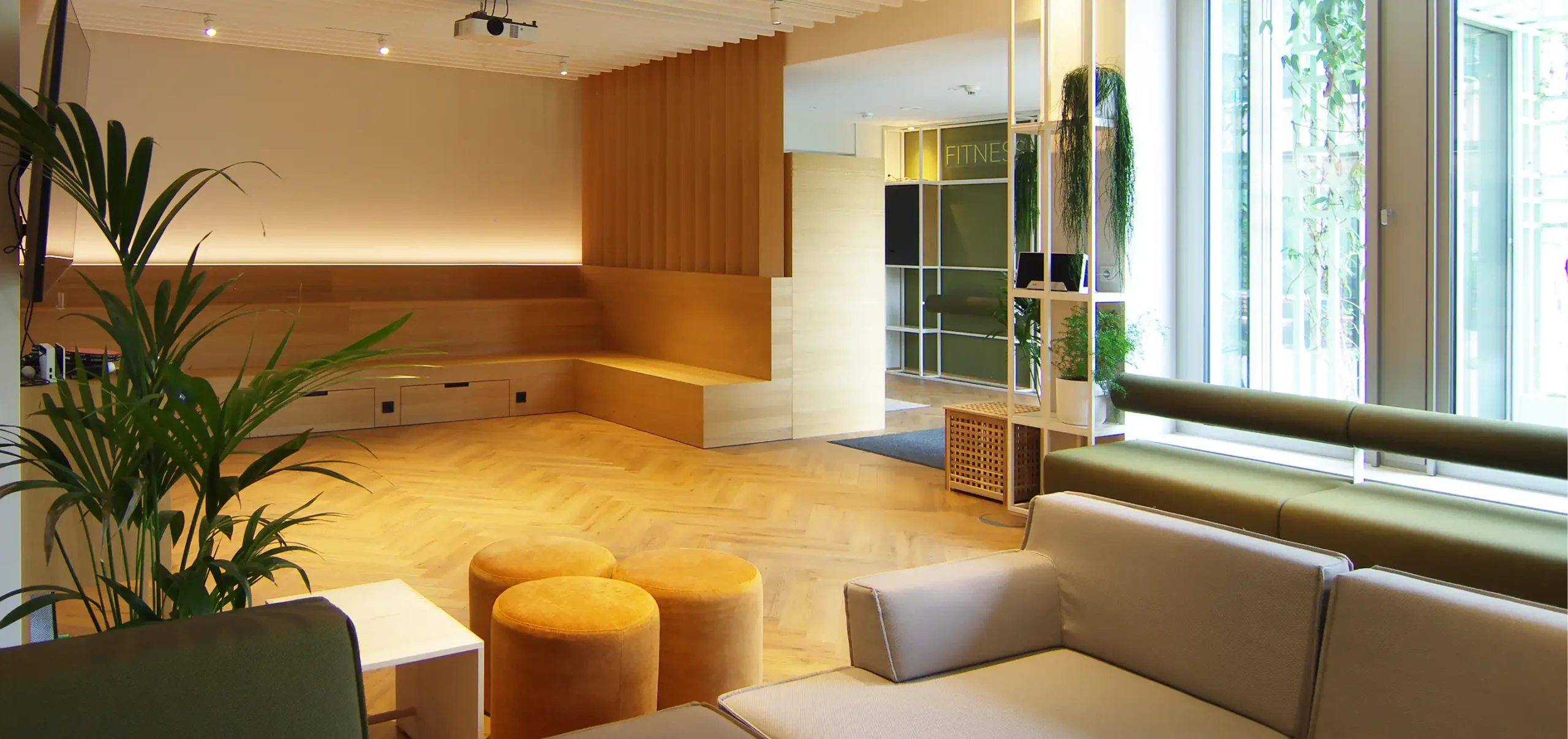 Büroräume von Bloom Offices, e, Beamer, schlichte Sitzecke besehend aus Unterschränken, Material Eiche, die in der Wand integriert sind, Stahl, Holz und frische Grüntöne, weitere funktionale und Elemente aus schlichter Eich