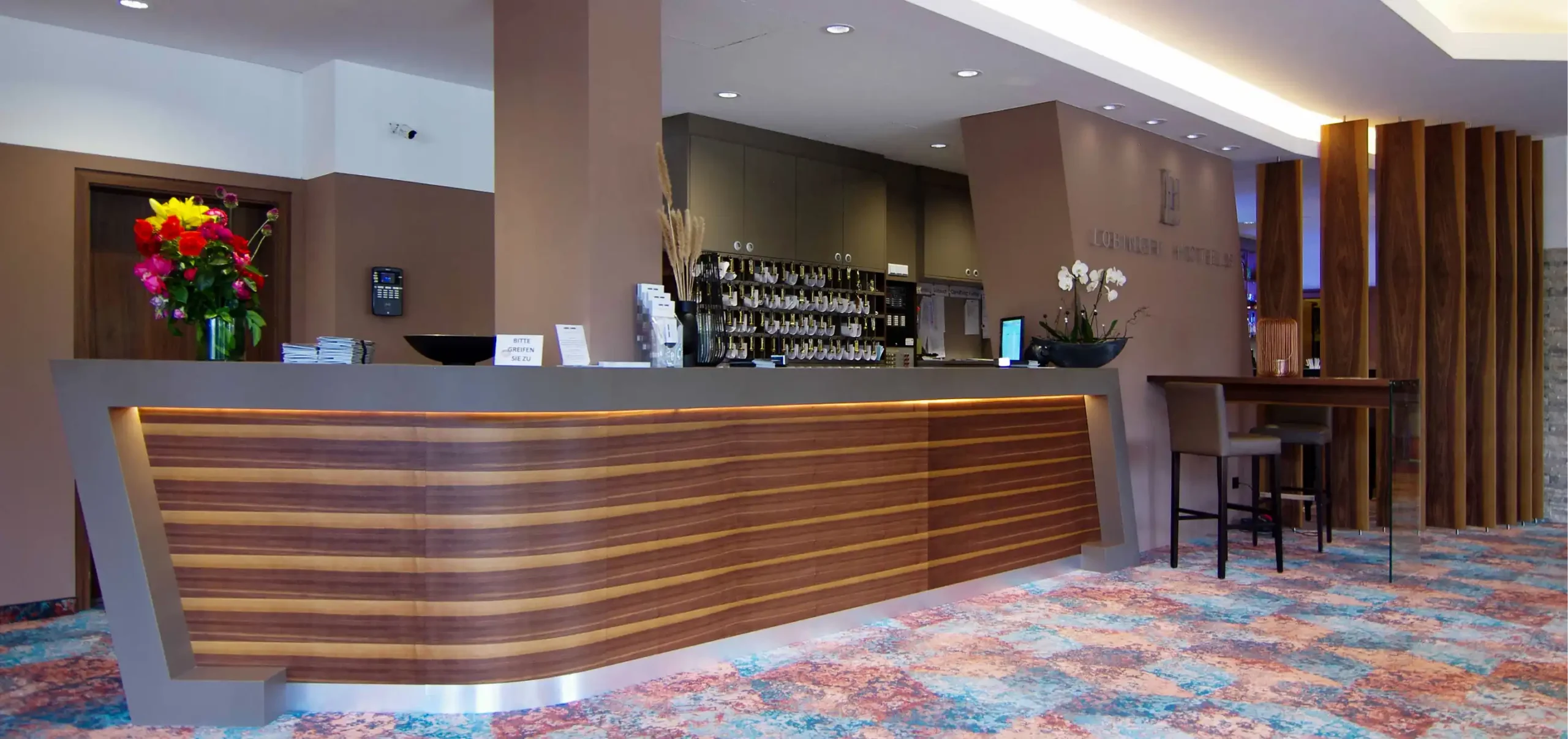 Hotel Lobinger, Empfangsbereich, Theke aus Nussbaumfurnier, Mineralwerkstoffe