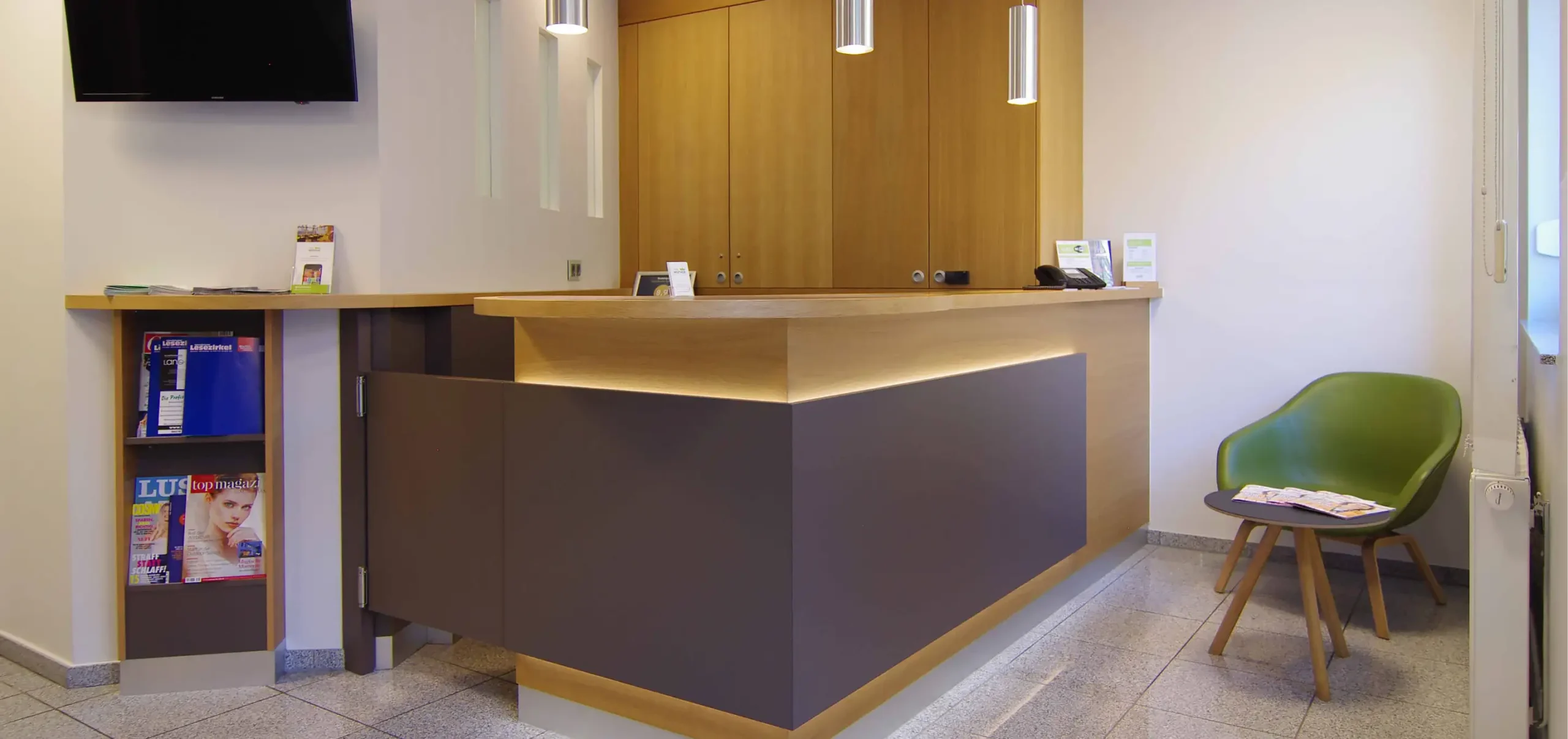 Hotel Neuthor Empfang, Rezeption, Rezeptionstresen, Empfangstresen mit maßgefertigten Einbauschrank mit Broschürenfach, links Monitor, rechts Sitzegelegenheit mit Beistelltisch, von Miller-Ladenbau