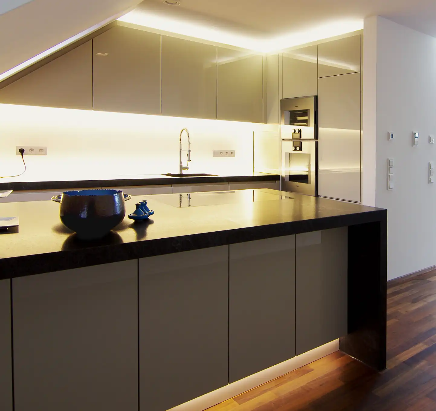 Maisonette-Wohnung, handgefertigte Küchenmöbel, Tresen mit Natursteinplatte, Hintergrund Küchenzeile, Arbeitsplatte aus Naturstein.