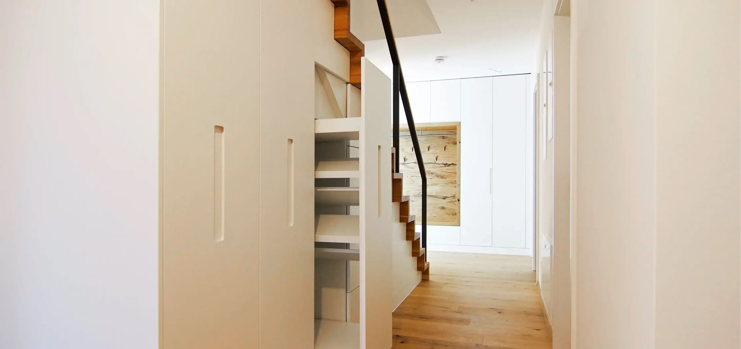 Innenausbau, Treppe mit speziell gefertigten Unterschrank, Verblendung mit integrierter Grifffräsung. Wandschrank mit integrierter Gasrobe